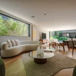 Sala de estar com janela ampla voltada à vegetação