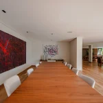 Mesa de jantar junto à obra de arte em ambiente integrado
