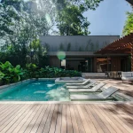 Piscina e deck de madeira entre a vegetação