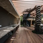 Área gourmet externa sob pergolado de madeira
